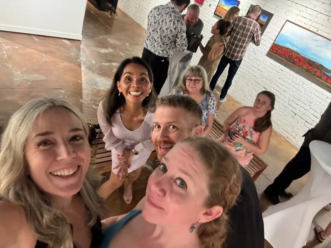 Guests taking a group selfie among the gallery paintings.