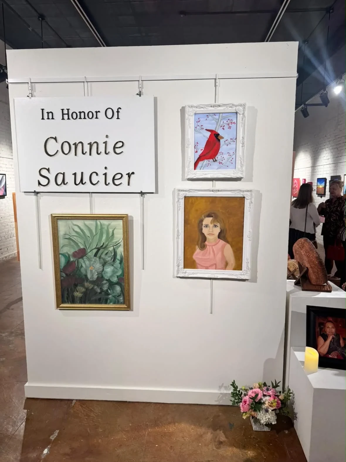 The display honoring Connie Saucier, with three framed paintings.